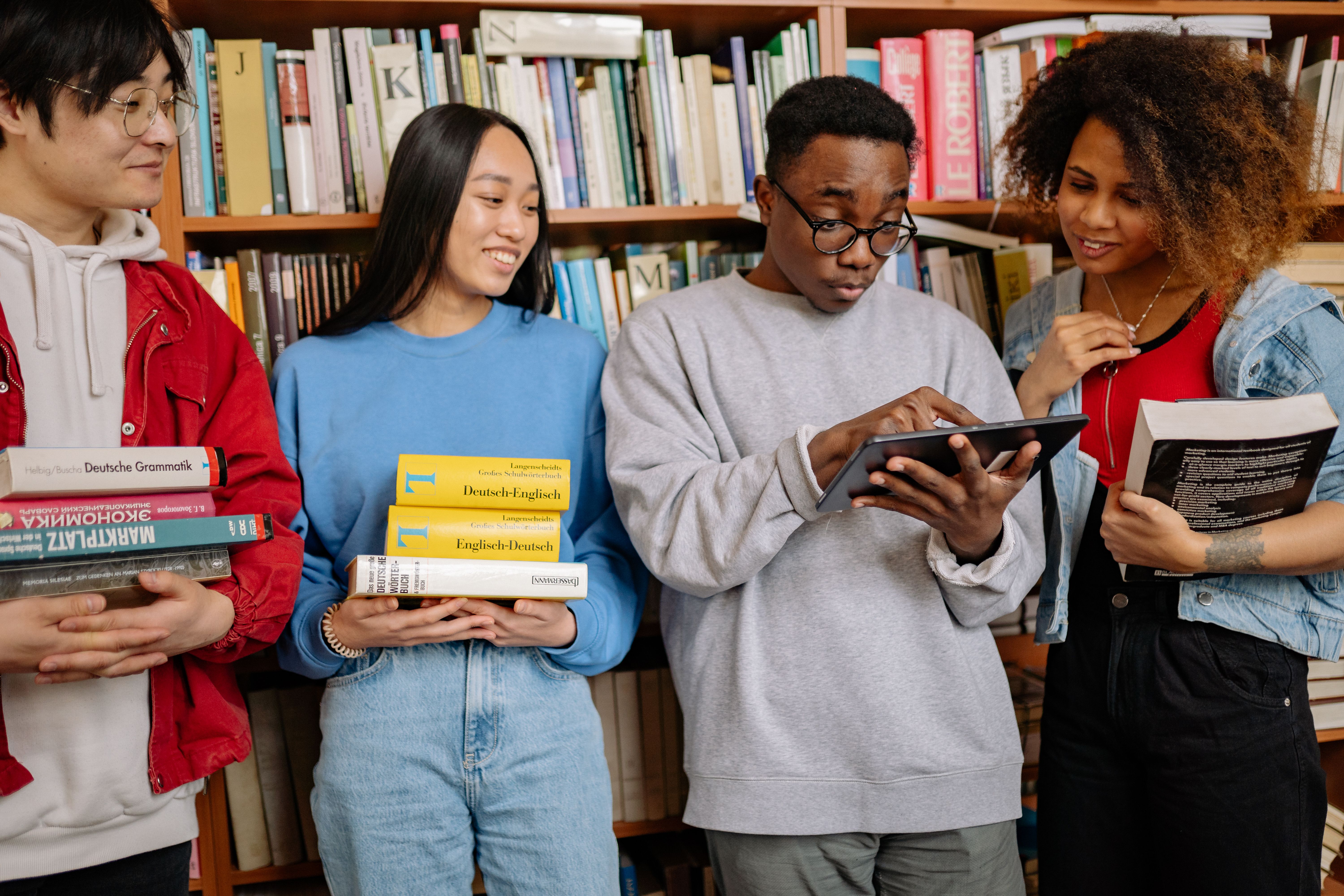 Grupo diverso de pessoas compartilhando livros em uma biblioteca